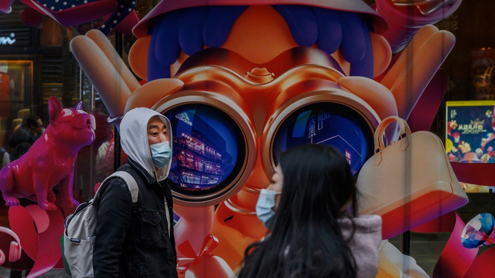 Shoppers walk past a luxury shopping mall in Beijng.