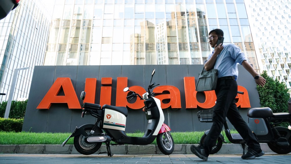 A pedestrian walks past Alibaba Group Holdings Ltd. signage displayed outside the company's offices in Beijing.