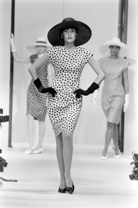 A model poses in a polka dot day dress accessorized with a hat and gloves from the Marc Bohan for Dior spring 1985 haute couture collection runway show.