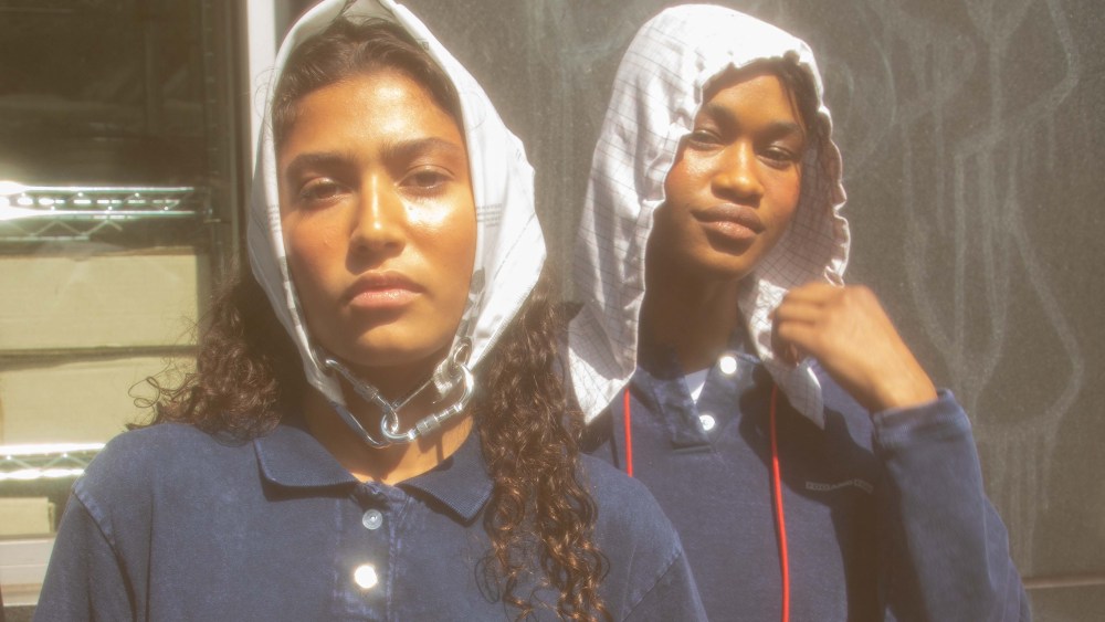 Outside the Foo & Foo spring 2023 runway show, two models in blue tops pose with white hoods on.