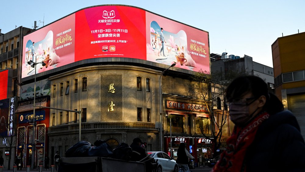 People walk past a billboard promoting the annual "Singles Day" shopping festival on November 10, 2021.