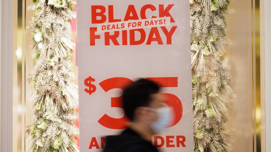 A Black Friday shopper walks by a store banner promoting Black Friday deals on Friday, Nov. 26, 2021, in the Westfield Oakridge mall in San Jose, Calif.