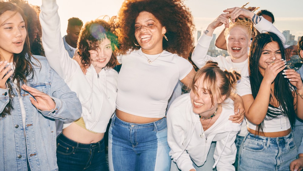 From the Hollister marketing campaign, young people gather and embrace, laughing and wearing denim.