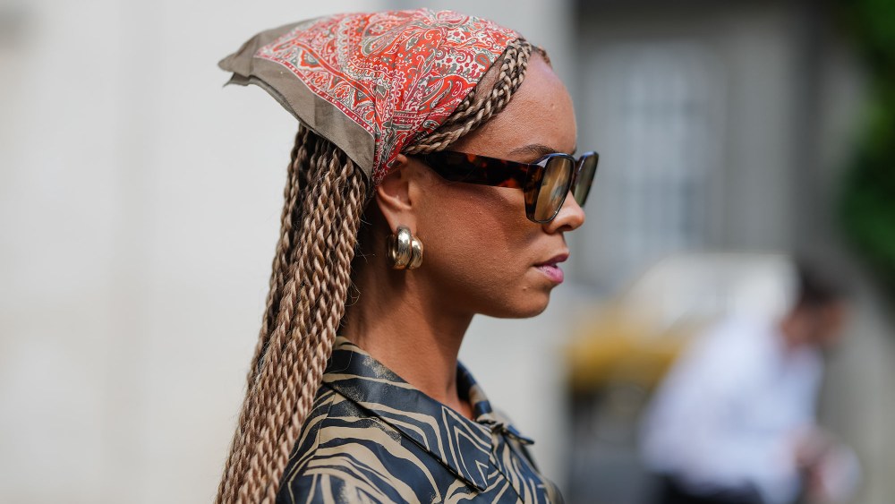 a woman wearing two hoop earrings and a silk scarf during copenhagen fashion week
