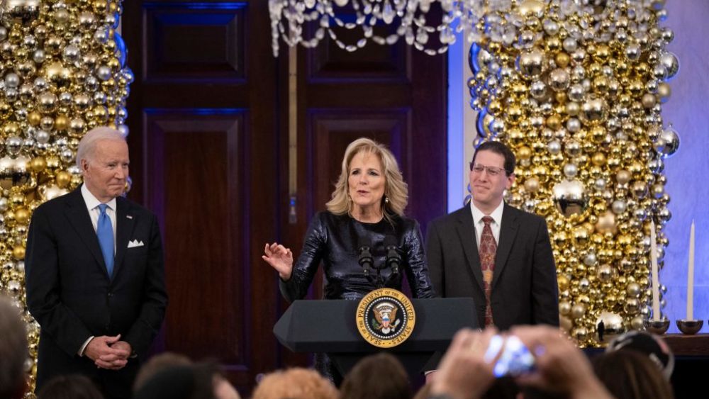 US President Joe Biden and Rabbi Charlie Cytron-Walker listen while US first lady Jill Biden speaks during a Hanukkah Holiday Reception in the Grand Foyer of the White House in Washington, DC, December 19, 2022. (Photo by Brendan Smialowski / AFP) (Photo by BRENDAN SMIALOWSKI/AFP via Getty Images)