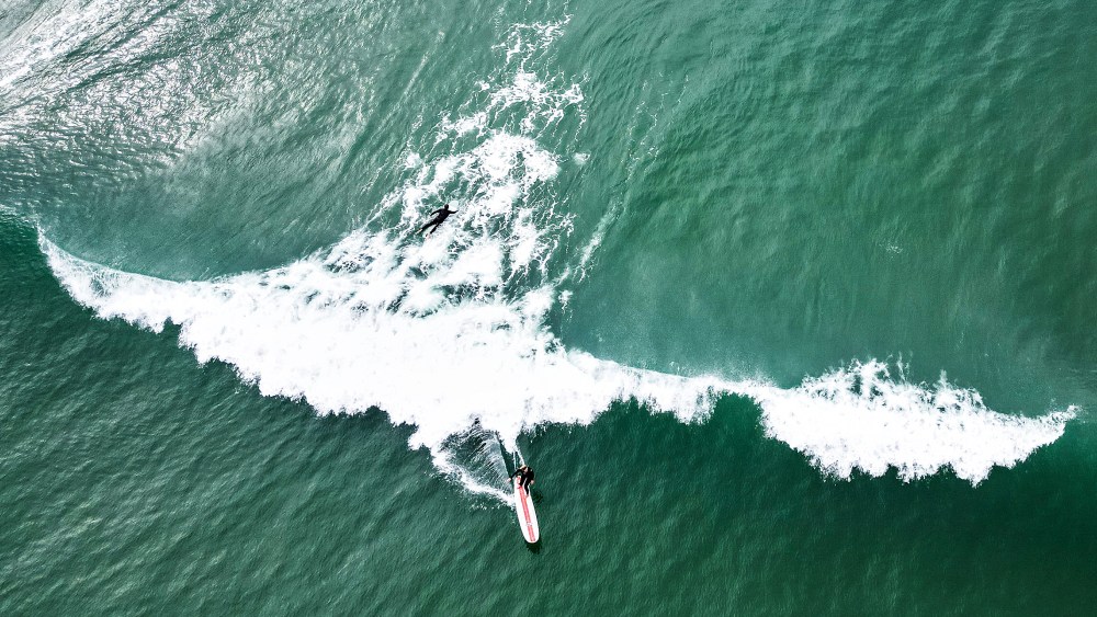 MIMIZAN PLAGE, FRANCE - OCTOBER, 2022: An unknown female surfer rides a wave at Plage Nord on October 10th, 2022 in Mimizan Plage, France. (Photo by Lars Baron/Getty Images)