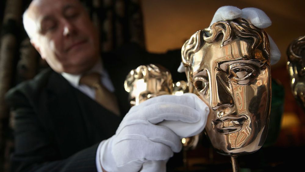 how to watch bafta, The BAFTA mask awards being polished by a butler ahead of the British Academy Film Awards in London.