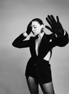 Alexander McQueen’s wool jacket with leather harness and Nana Jacqueline’s polyester shorts. Wolford tights; Givenchy gloves; Saint Laurent earrings; Givenchy cuffs.