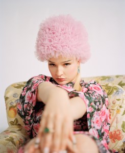 Christopher Kane’s recycled polyester dress and cape. Marc Jacobs boots. Binata Millinery tulle hat. Anne Sisteron 18-karat yellow gold blue topaz and diamond luxe Olympia earrings; Boucheron Fuzzy, the Leopard Cat ring with one green cushion tourmaline, champagne round diamonds, round diamond, cabochon emeralds, black lacquer, 18-karat pink gold.