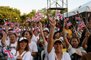 People raise British flags as they wait for the livestream of the coronations taking place in London of Britain's King Charles III and Britain's Camilla, Queen Consort, while gathered in Quezon City, suburban Manila on May 6, 2023. (Photo by JAM STA ROSA / AFP) (Photo by JAM STA ROSA/AFP via Getty Images)