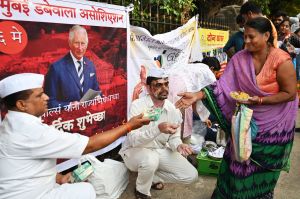 'Dabbawalas', Mumbai's famed cycle-borne tiffin delivery men, distribute sweets and food to the needy to celebrate the coronation of Britain's King Charles III and Britain's Camilla, Queen Consort, in Mumbai on May 6, 2023. (Photo by SUJIT JAISWAL / AFP) (Photo by SUJIT JAISWAL/AFP via Getty Images)