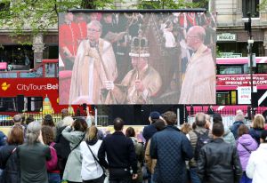 Members of the public gather in the grounds of Belfast City Hall, to watch the Coronation Ceremony for the new King and Queen, Britain's King Charles III and Britain's Queen Camilla, in Belfast on May 6, 2023. - The set-piece coronation is the first in Britain in 70 years, and only the second in history to be televised. Charles will be the 40th reigning monarch to be crowned at the central London church since King William I in 1066. Outside the UK, he is also king of 14 other Commonwealth countries, including Australia, Canada and New Zealand. Camilla, his second wife, will be crowned queen alongside him and be known as Queen Camilla after the ceremony. (Photo by PAUL FAITH / AFP) (Photo by PAUL FAITH/AFP via Getty Images)