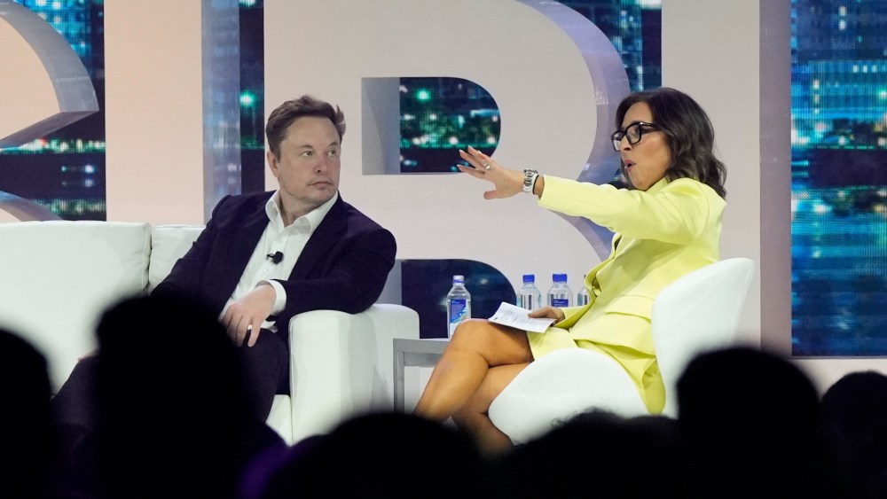 Twitter CEO Elon Musk, center, speaks with Linda Yaccarino, chairman of global advertising and partnerships for NBC,