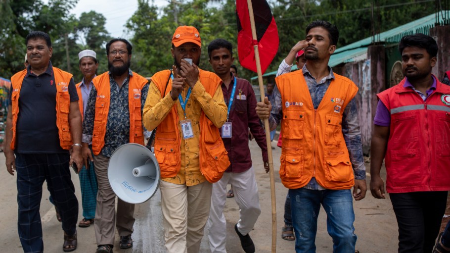 Cyclone Preparedness Program workers use a megaphone and hold 'signal 8' flags at Shahpori island beach area in Teknaf ahead of Cyclone Mocha's landfall. Bangladesh has raised the cyclone warning signal to 10 for Cox's Bazar and Teknaf areas.