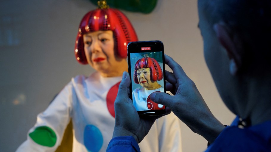 A person takes a video of a realistic robot of Japanese artist Yayoi Kusama in the window of the Louis Vuitton store on Fifth Avenue in New York on January 18, 2023.