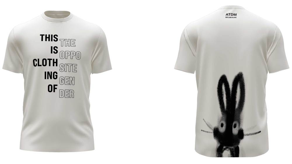 A white T-shirt from the ATDM x Nayland Blake collection features black letters on the front reading "this is clothing of this opposite gender" and a black spray paint-effect bunny at the back bottom.