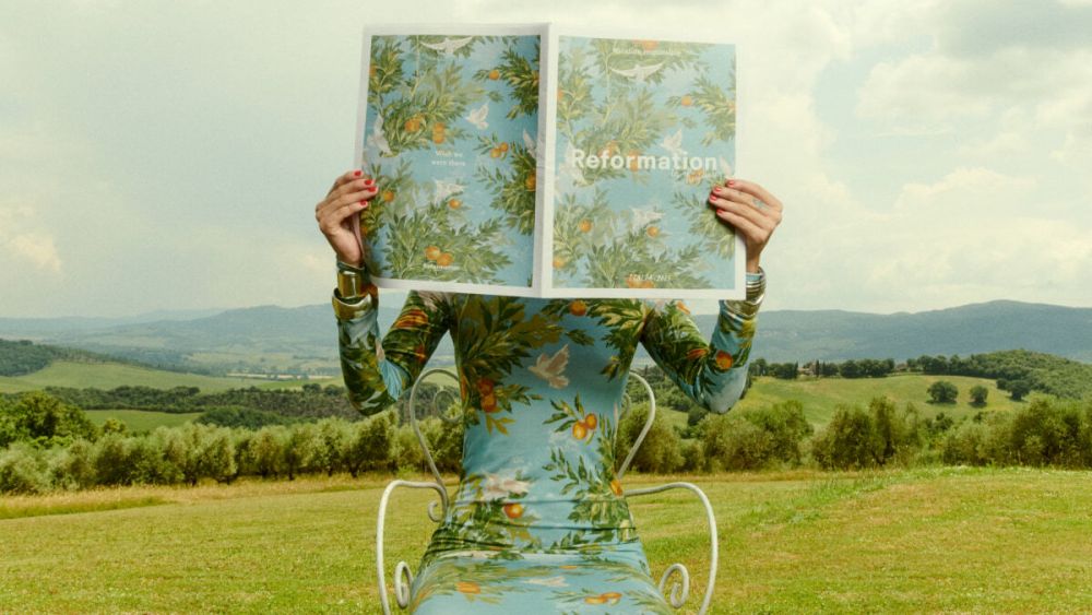 Ref's new flagship is coming soon. An ad shows a mountain backdrop with tropical dress and newspaper motif.