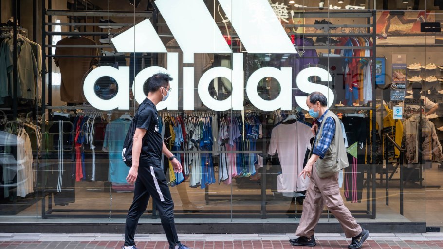 Pedestrians walk past the German multinational sportswear brand Adidas store in Hong Kong.