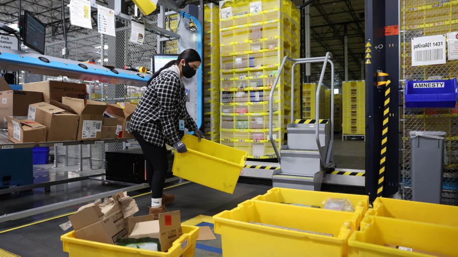 A worker fulfills orders at an Amazon same day shipping facility on Nov. 23, 2022 in Richmond, California. The 200,000-square-foot same-day shipping facility can deliver some packages within hours of the order being received.