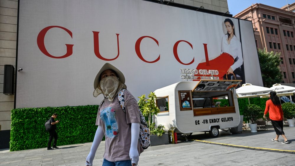 A woman walks past a billboard for Italian luxury fashion brand Gucci at a shopping mall in Beijing on September 15, 2023.