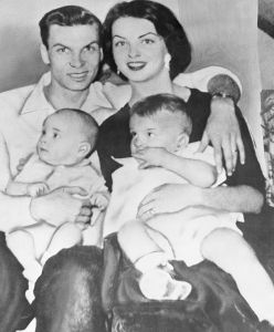 Mrs. Mary Leona Gage Ennis, the young lady who won the title of Miss U.S.A. in the Miss Universe contest and then lost it when it was discovered she was married and the mother of two children, is shown in this photo made in 1956 with her husband, Gene and their sons David, left, and Gene Jr. at the time she was 17 years old.