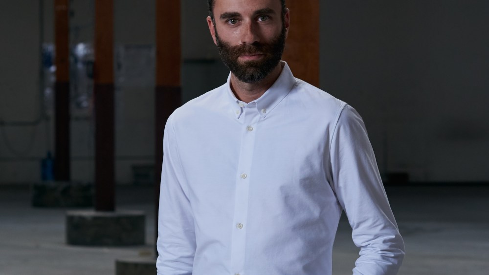MycoWorks CEO Matt Scullin wearing a crips white button-down and slacks in the factory space.