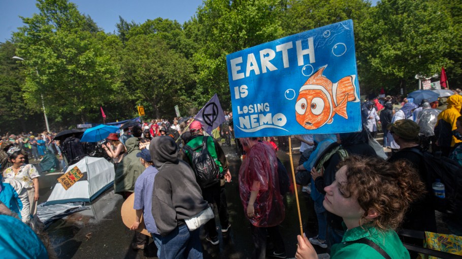 THE HAGUE, NETHERLANDS - MAY 27: A woman holds a self made sign reading 'Earth is losing Nemo' as she  blocks the A12 motorway during an Extinction Rebellion led protest to command an end to all fossil fuel subsidies on May 27, 2023 in The Hague, Netherlands. Organisers want among others more honesty about the climate crisis, a stop to biodiversity loss and net zero carbon emissions by 2025.