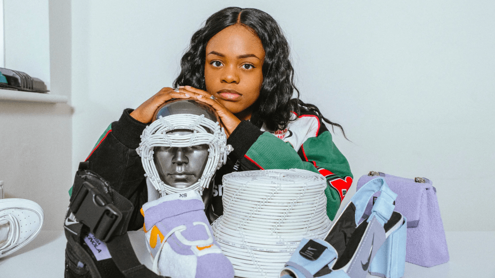 A picture of Tega Akinola amongst shoes she designer in colorful swatches. She is a designer participating in Slow Factory's Garment to Garment pilot.