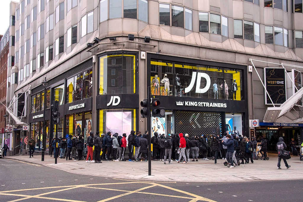 A large group of shoppers wait outside the JD Sports store on London's Oxford Street on April 12, 2021.