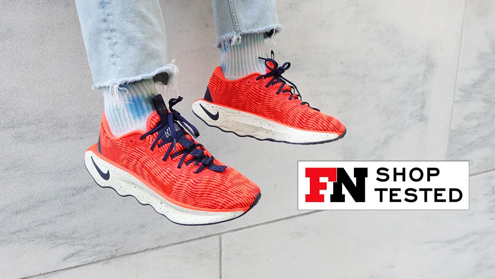 nike motiva walking shoes in a red colorway on a footwear editor testing the footwear.