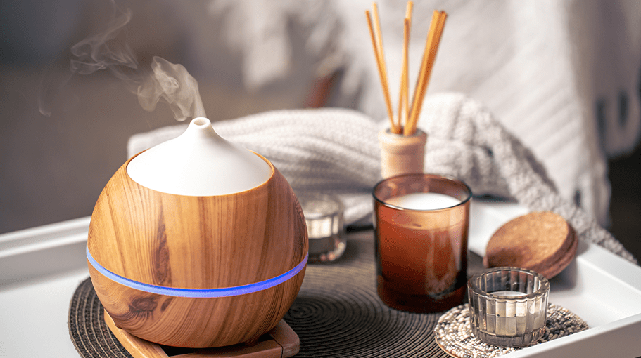 Oil diffuser on blurred background near candles