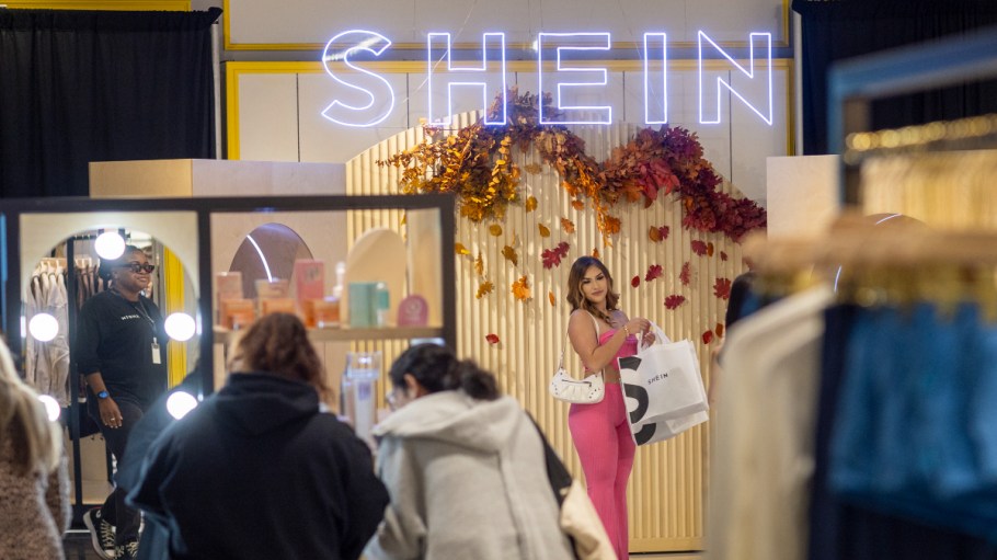 Ontario, CA - October 19: Shoppers Ashley Sanchez, center, of Fontana, poses for her friend Joscelin Flores, not pictured, who was taking photos with their bags of merchandise after being among the first group of shoppers taking the opportunity to shop on the opening day of fast fashion e-commerce giant Shein, which is hosting a brick-and-mortar pop up inside Forever 21 at the Ontario Mills Mall in Ontario Thursday, Oct. 19, 2023.