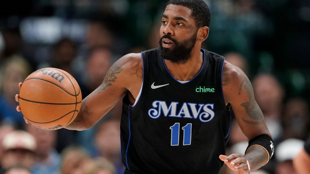 Kyrie Irving dribbles basketball in Dallas Mavericks jersey.