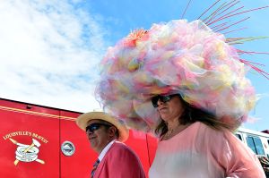 LOUISVILLE, KY - MAY 07:  A man and woman wearing festive hats walk the grounds prior to the 142nd running of the Kentucky Derby at Churchill Downs on May 07, 2016 in Louisville, Kentucky.  (Photo by Logan Riely/Getty Images)