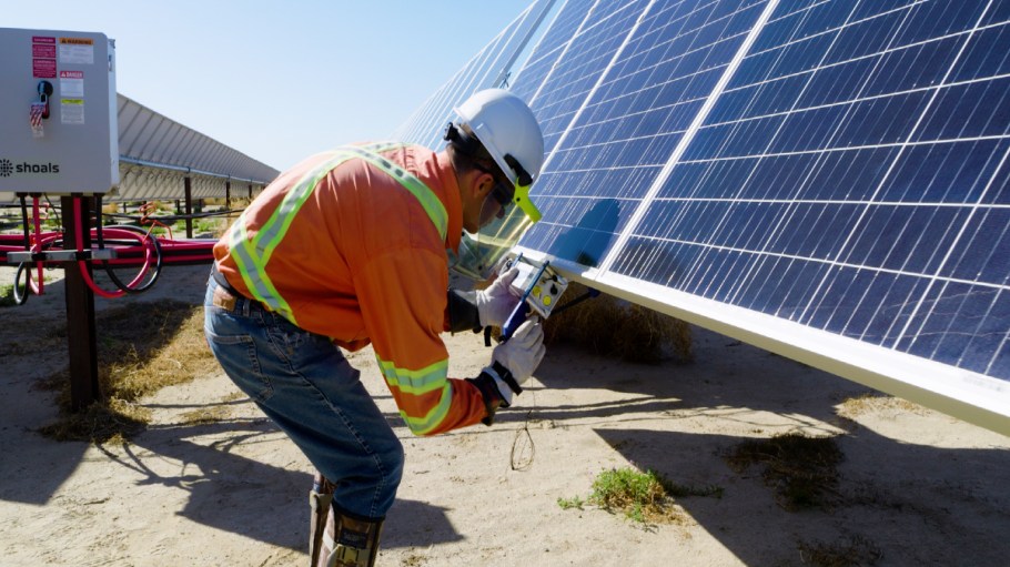 An employee works at a solar farm in Baldy Mesa, California, where Amazon tech is being deployed for renewable energy practices.
