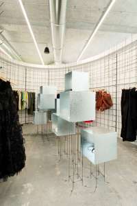 Galvanized steel cubes and steel mesh walls commune with exposed heating ducts overhead.