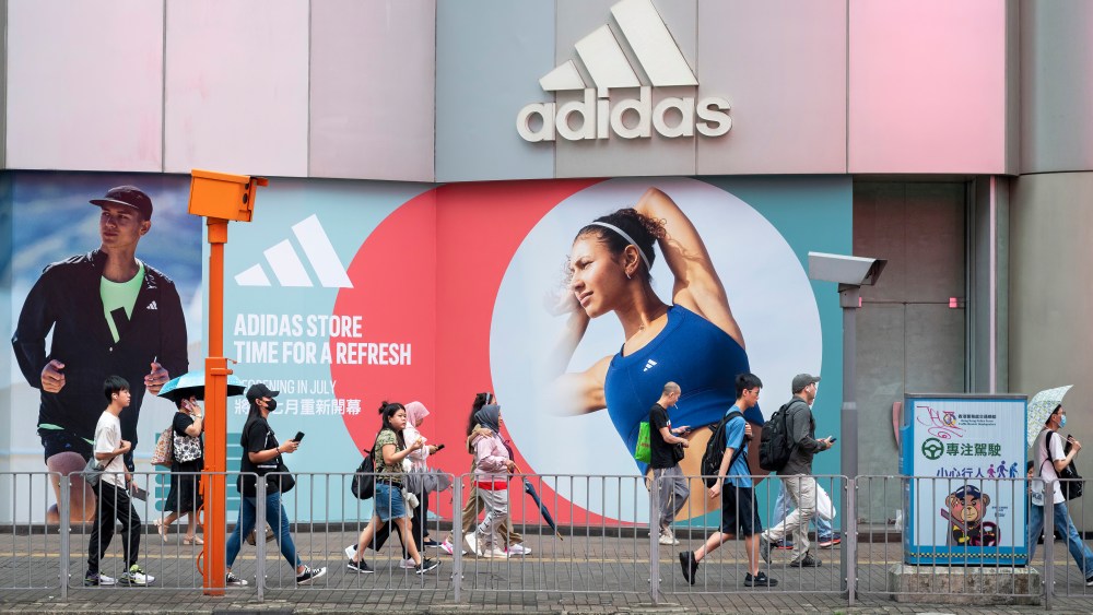 Pedestrians walk past an Adidas store in Hong Kong.