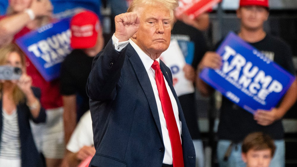 Former President and current Republican presidential nominee Donald Trump raises his fist as he leaves the stage during a campaign event on Saturday, August 3, 2024 in Atlanta, GA.