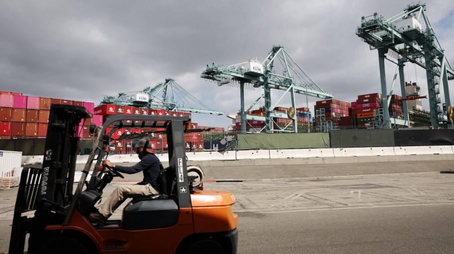 A worker drives a forklift near shipping containers stacked at the Port of Los Angeles on September 20, 2024.