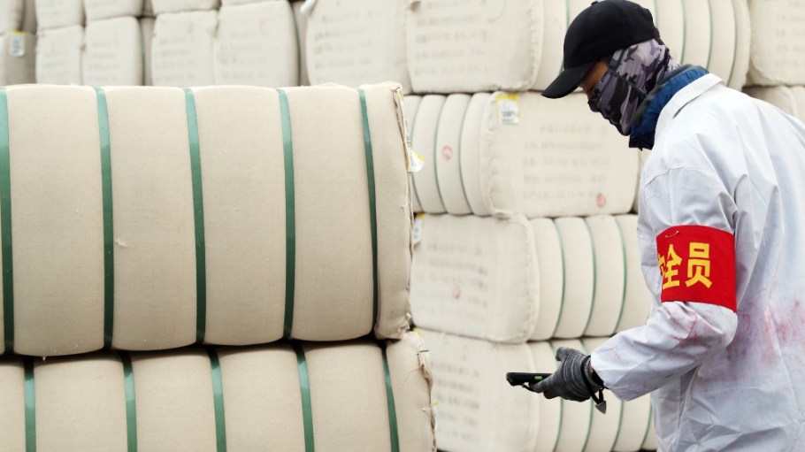 An employee checks bundles of pressed cotton at a cotton enterprise on December 6, 2023 in Urumqi, Xinjiang Uygur Autonomous Region of China.