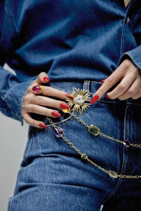 Khaite cotton jeans; The Frankie Shop cotton denim shirt; Verdura Ray brooch in gold, platinum and diamond and confetti necklace in gold and lemon quartz, Madeira citrine, blue topaz,

peridot, amethyst, rutilated quartz, aquamarine, prasiolite and citrine; Hornsdorf Venus ring in Nigerian rubellite, cabochon brilliant-cut white diamonds and satin-finished 22-karat yellow gold.