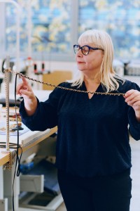 Checking the signature braided metal and leather chain at Chanel’s AVH handbag factory.