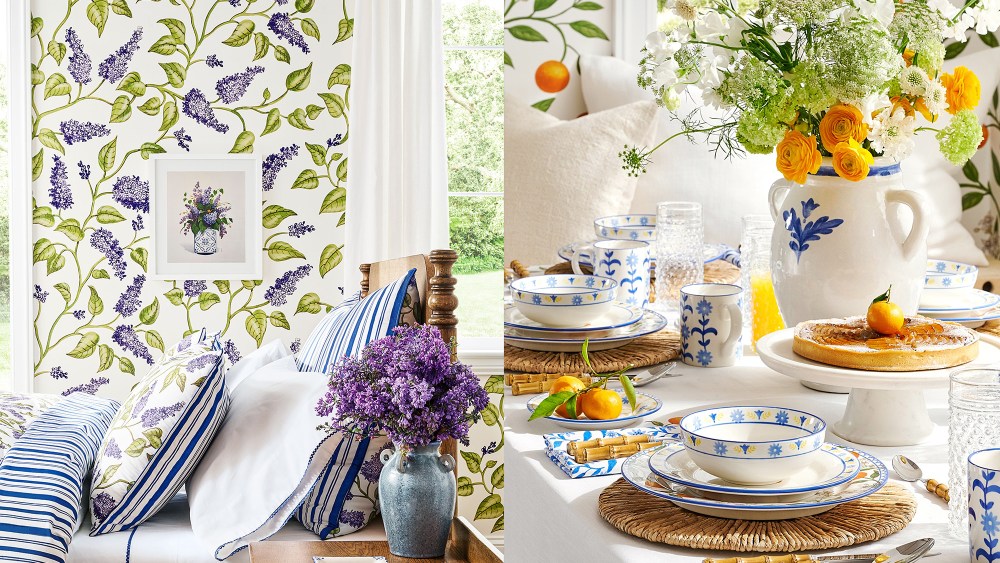 a well-made bed with flowers on the bedside table and a floral-printed wallpaper; table decorated with flowers, fancy dinnerware, and fruits