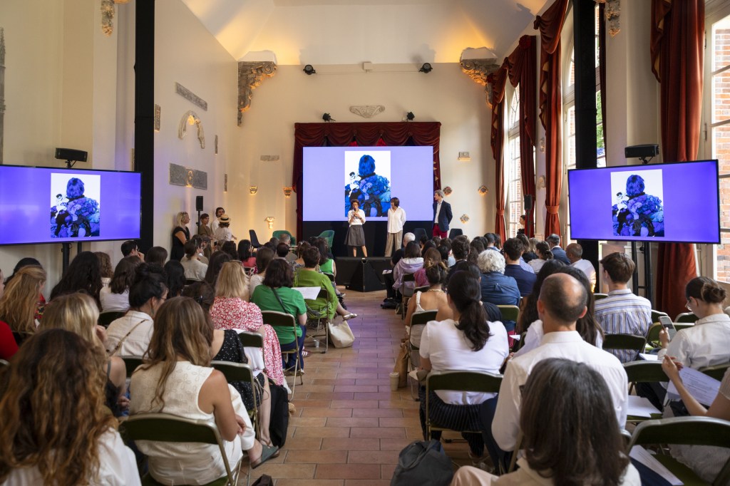 a speaker among guests at the Paris Good Fashion's Midsummer Camp
