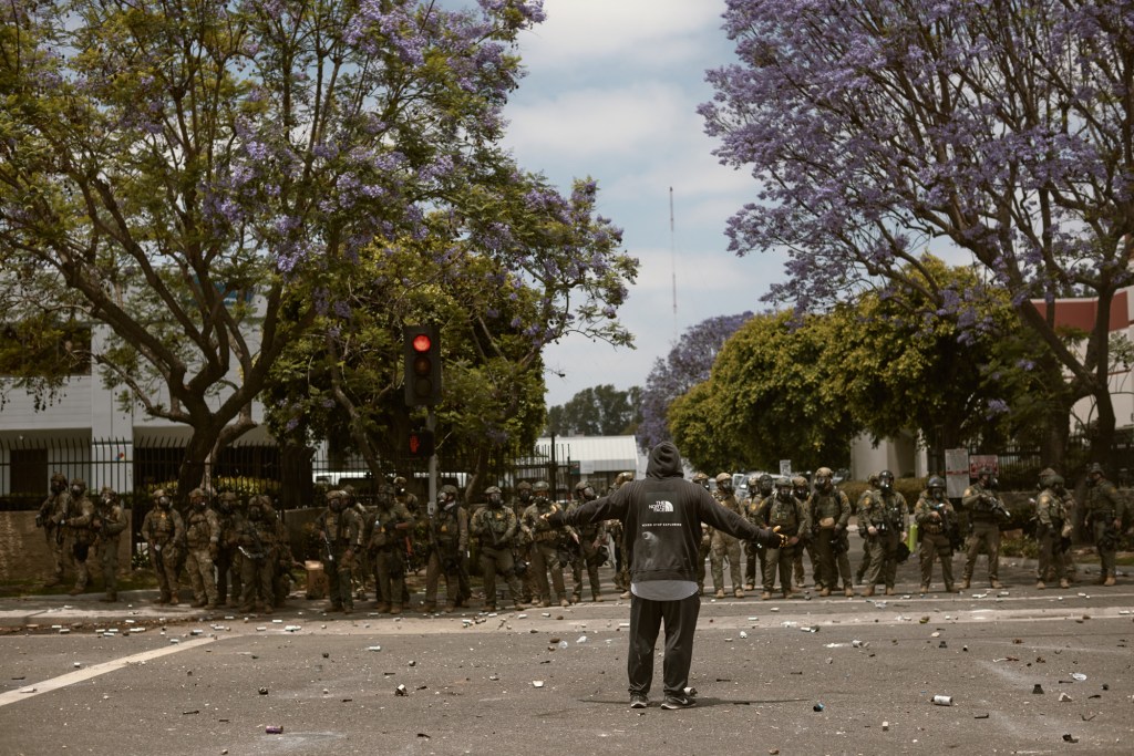 LOS ANGELES, CALIFORNIA - JUNE 7: Protests and confrontations between immigration rights supporters and law enforcement take place in Paramount and downtown Los Angeles, California, following recent raids by Immigration and Customs Enforcement (ICE) and Department of Homeland Security (DHS) agents on June 7, 2025. Demonstrators are seen using blockades and facing tear gas, flashbang grenades, and pepper ball shots, while rising tensions lead to damaged property across the affected areas. (Photo by Taurat Hossain/Anadolu via Getty Images)