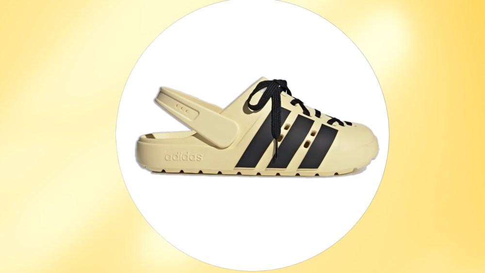 yellow adilette clog from adidas over a white circle and pale yellow, strobe-effect background