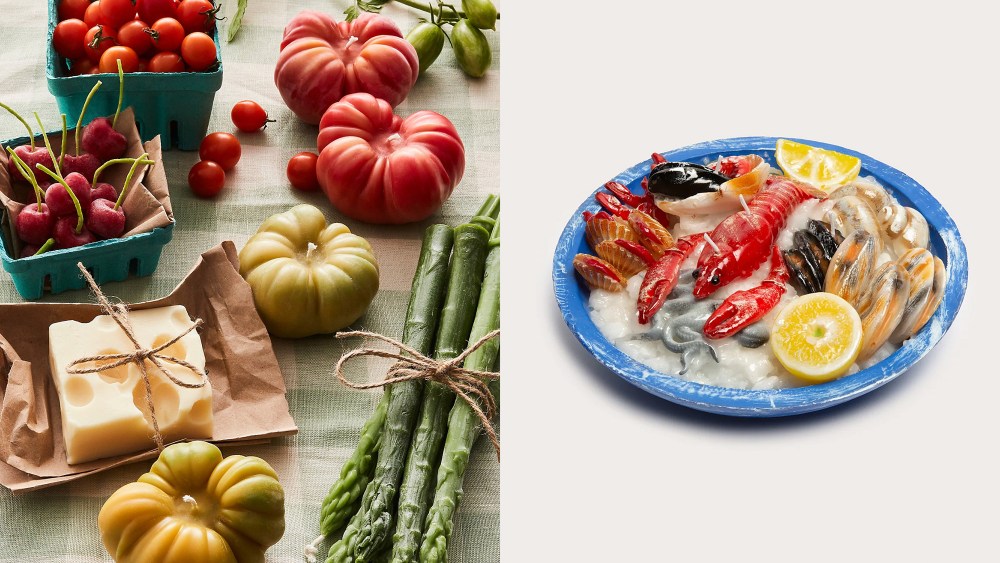 spread of many candles shaped out like vegetables, fruits, and cheese; candle that looks like a seafood platter with lemons and a lobster