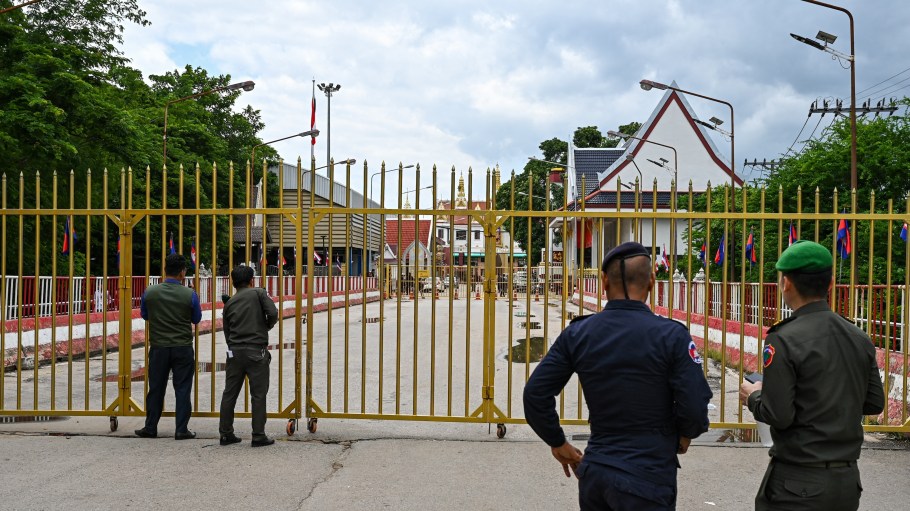 Cambodian police officials stand next to the closed gate at Poipet International border checkpoint between Cambodia-Thailand, at Poipet town in Banteay Meanchey province on June 24, 2025.
