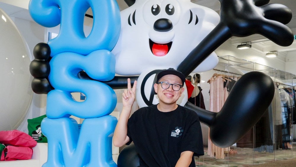 Verdy posing with Vick, the artist's signature cartoon character, holding a DSM sign at Dover Street Market in London.