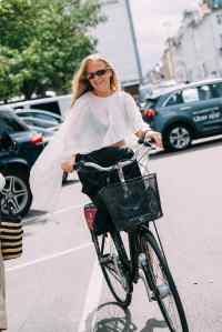 Female on bicycle wearing white sheer pleated shirt and sunglasses at Copenhagen Spring 2026 Fashion Week